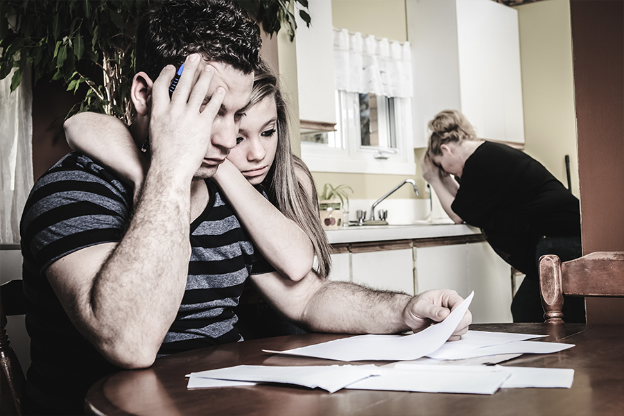 family at kitchen table worried about debt